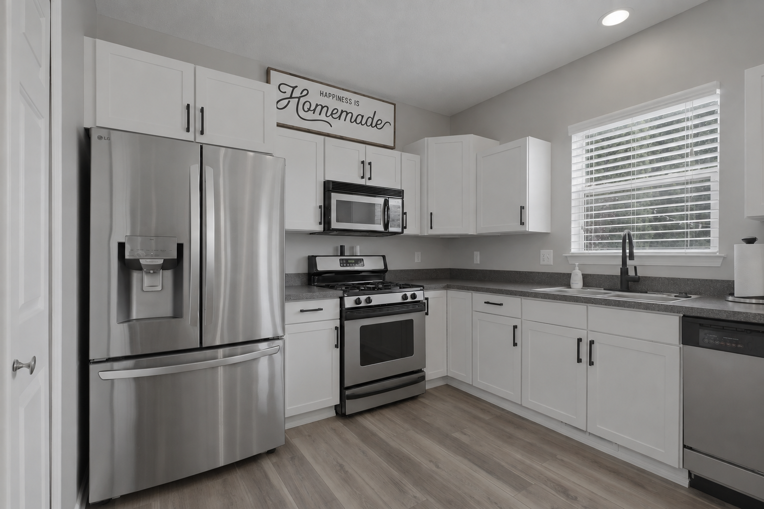 Flat, unedited photo of a kitchen with white cabinets and stainless steel appliances